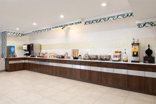 a large kitchen with a counter with many appliances at GLō Best Western Bronx NYC in Bronx