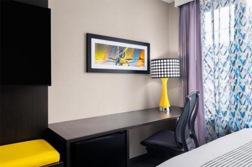 a hotel room with a desk and a lamp at GLō Best Western Bronx NYC in Bronx