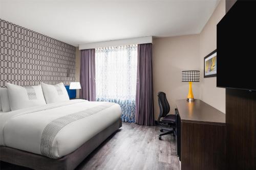 a hotel room with a bed and a desk and a window at GLō Best Western Bronx NYC in Bronx