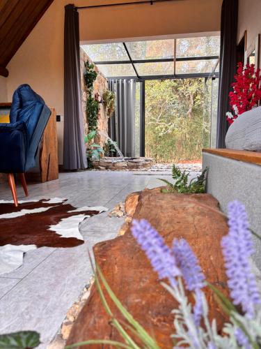 a living room with a couch and a large window at Recanto da Natureza in Brotas