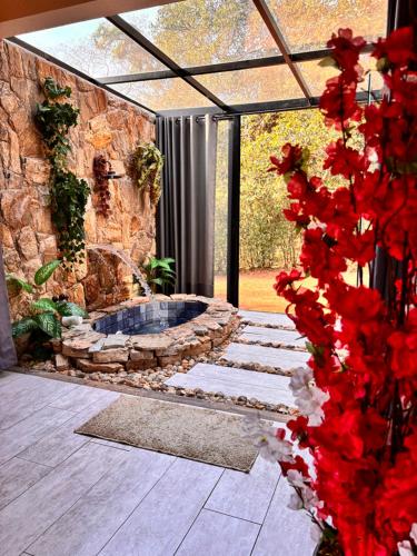 a patio with a stone wall and a fire pit at Recanto da Natureza in Brotas