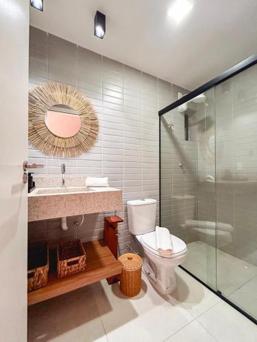 a bathroom with a toilet and a sink and a mirror at Kasa Kanui Milagres in São Miguel dos Milagres