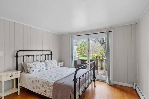 a bedroom with a bed and a balcony at Charming Kennebunk Cape - Walk to Dock Square! in Kennebunkport