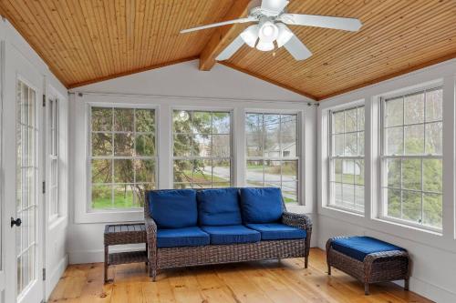 a living room with a blue couch and windows at Charming Kennebunk Cape - Walk to Dock Square! in Kennebunkport