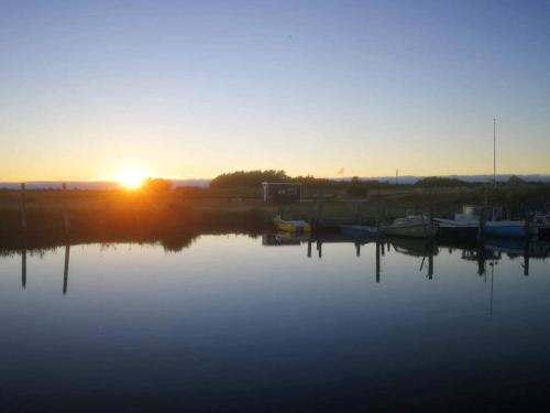 a sunset over a body of water with boats at 6 person holiday home in Dannemare-By Traum in Dannemare