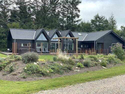 a black house with a garden in front of it at 12 person holiday home in Ansager-By Traum in Ansager