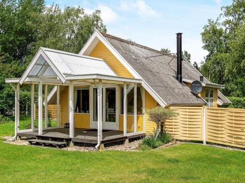 a small yellow house with a porch at 4 star holiday home in Dannemare in Dannemare