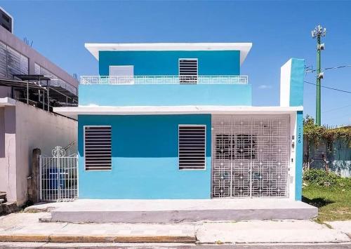 a blue building with a gate in front of it at La Casita de Ceiba in Ceiba