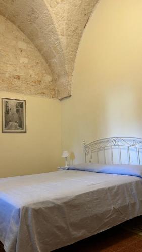 a bedroom with a bed with a white bedspread at CASINA 1806 Selva di Fasano in Selva di Fasano