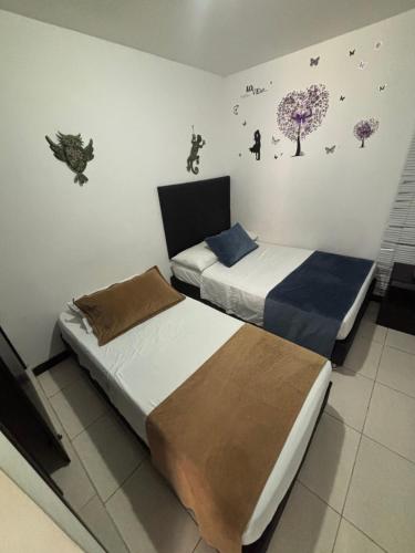 a bedroom with two beds and a wall with stickers at Apartamento Aroma de Café in Montenegro