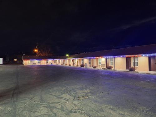 an empty parking lot in front of a building at night at Patriot Stay Motel in Vernal