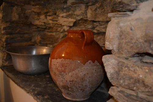 a vase sitting on a counter next to a stone wall at La Chouette in Pieve di Teco