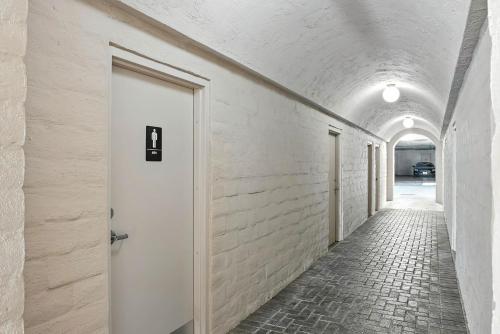 a corridor with a white door and a brick alley at Solana Gem - Need to add in Solana Beach
