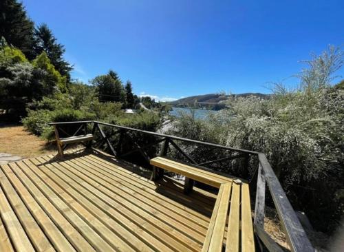 a wooden boardwalk with a bench on top of it at Cabañas en Valdivia LU in Valdivia