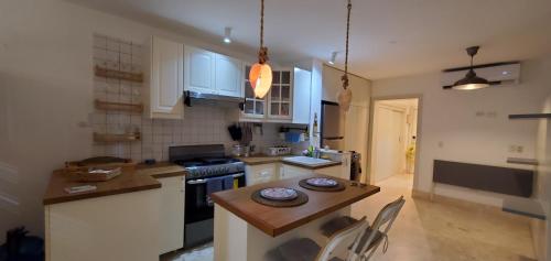 a kitchen with white cabinets and a table with chairs at Caribean Seascape in Villas del Mar