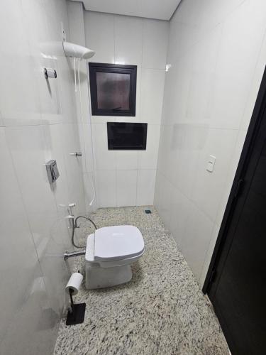 a white bathroom with a toilet on a counter at Estância Ana S Diniz in Barretos