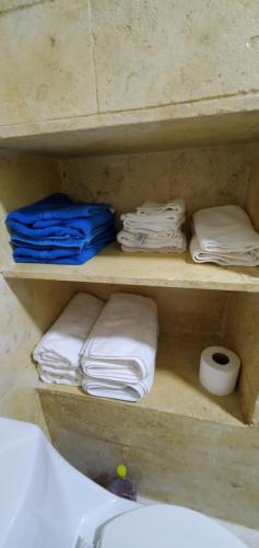 a shelf with folded towels and a sink in a bathroom at Caribean Seascape in Villas del Mar