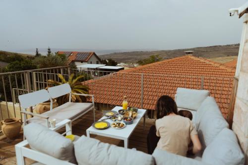 a woman and a child sitting on a balcony at mimar מימאר אירוח כפרי מפנק in Had Nes