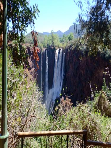 a waterfall on the side of a cliff at Riad Cascades d'Ouzoud in Ouzoud