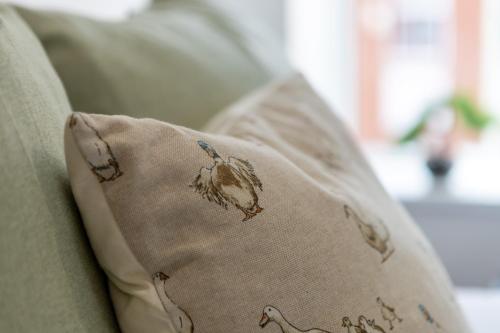 a pillow with a bird on it sitting on a couch at St James Court Aparthotel in Derby