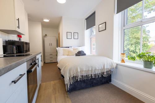 a kitchen with a bed in a room with a window at St James Court Aparthotel in Derby