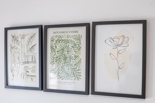 three framed drawings of plants and a flower on a shelf at St James Court Aparthotel in Derby