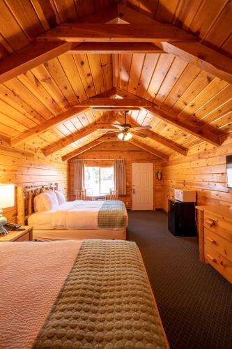 a bedroom with two beds in a wooden cabin at Bryce Canyon Inn in Tropic