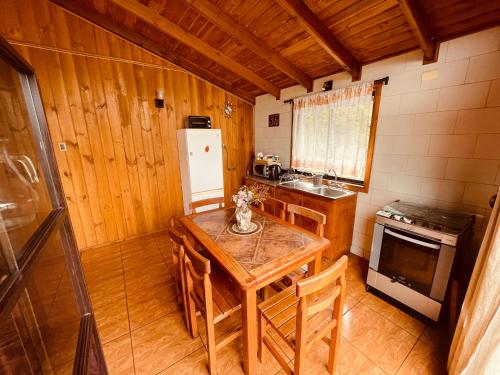 a kitchen with a wooden table and a refrigerator at Cabañas en Valdivia LU in Valdivia