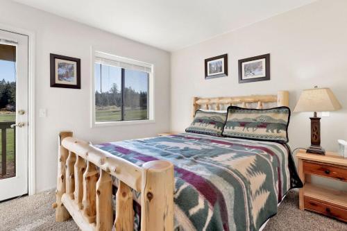 ein Schlafzimmer mit einem Holzbett und einem Fenster in der Unterkunft Sunny Side Up - Golf & Ski Townhouse at Bear Mountain Resorts in Big Bear Lake