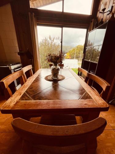 a wooden table in a room with a large window at Cabañas en Valdivia LU in Valdivia