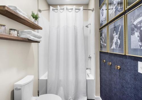 a bathroom with a white shower curtain and a toilet at King Bed,Steps To Broadway,Park Free, No Fees in Nashville