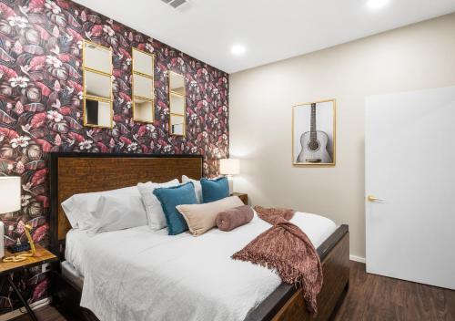 a bedroom with a large bed with a floral accent wall at King Bed,Steps To Broadway,Park Free, No Fees in Nashville