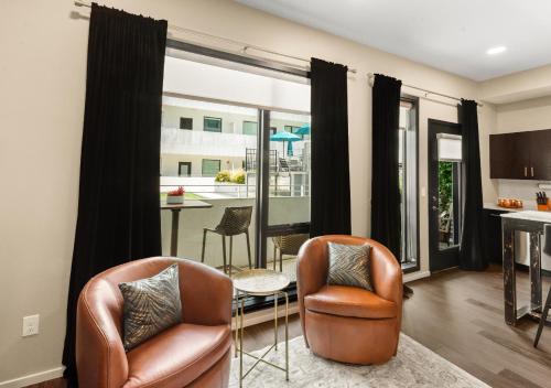 a living room with two chairs and a table at King Bed,Steps To Broadway,Park Free, No Fees in Nashville