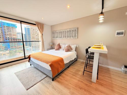 een slaapkamer met een bed, een bureau en een raam bij Loft Elegante y Centra en Bogotá in Bogota