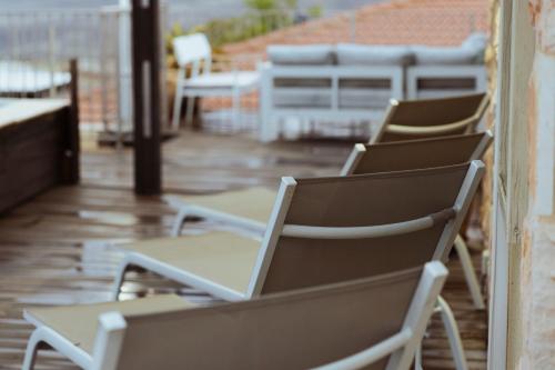 a row of chairs sitting on a patio at mimar מימאר אירוח כפרי מפנק in Had Nes