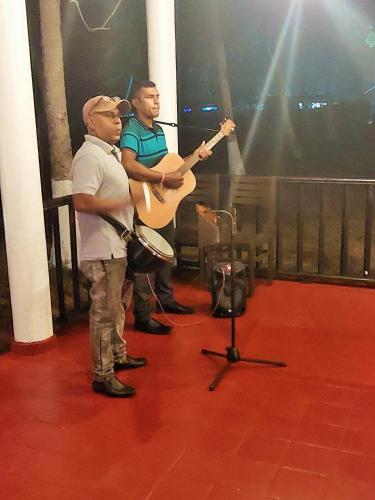 two men playing guitar and drums in a room at Helios Beach Resort in Tangalle