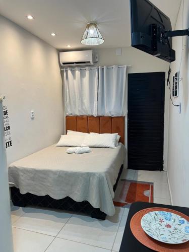 a bedroom with a bed with two towels on it at Casa Laranja no Centro de Pipa a 3 min das Praias in Pipa
