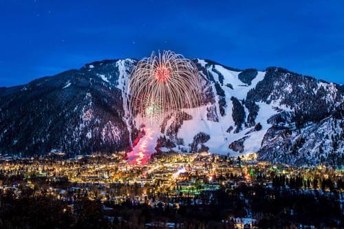 a fireworks display in front of a snow covered mountain at Chaparral Aspen Ranch Cabin in Woody Creek