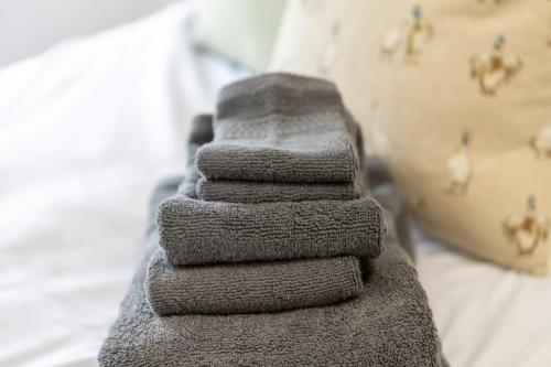 a stack of towels sitting on top of a bed at St James Court Aparthotel in Derby