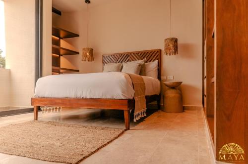 a bedroom with a bed with white sheets and pillows at Peregrina Tulum Lux Aparthotel in Tulum