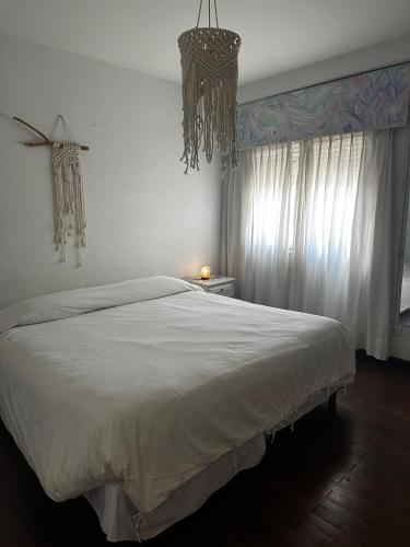 a bedroom with a large white bed and a chandelier at Yunga in Salta