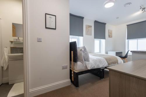 a bedroom with a bed and a sink in a room at St James Court Aparthotel in Derby