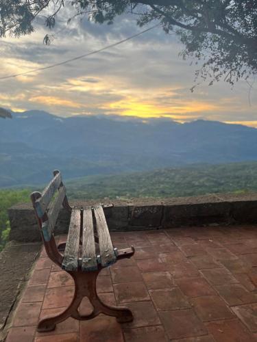 a wooden bench sitting on a patio with a view at Casa Real Barichara in Barichara