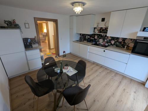 a kitchen with a glass table and black chairs at Privatzimmer und Küche mit Balkon und Ausblick in Golling an der Salzach