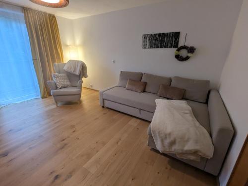 a living room with a couch and a chair at Privatzimmer und Küche mit Balkon und Ausblick in Golling an der Salzach