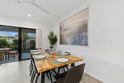 a dining room with a wooden table and chairs at Trinity Oasis Spa BBQ & Family Retreat in Trinity Beach