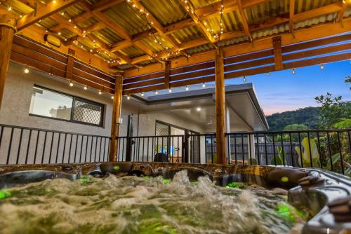 a deck with a hot tub on a house at Trinity Oasis Spa BBQ & Family Retreat in Trinity Beach