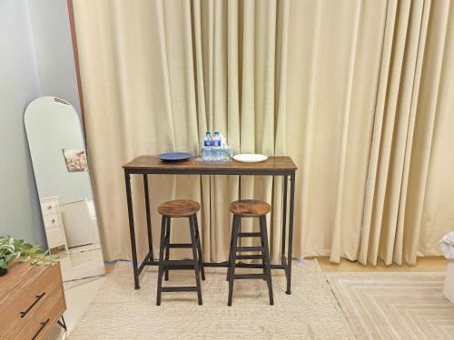 a small table with two stools in front of a curtain at Modern Studio Near Dubai World Trade Centre in Dubai
