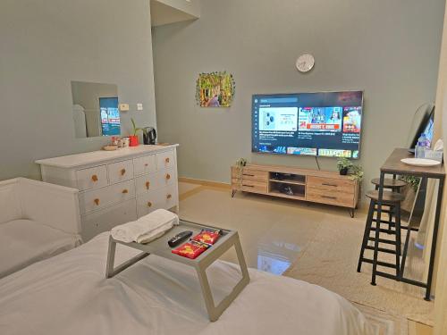 a living room with a tv and a couch and a table at Modern Studio Near Dubai World Trade Centre in Dubai