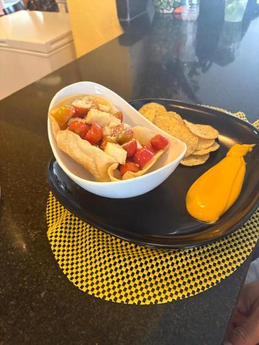 a hot dog in a bowl on a plate with chips at Caribean Seascape in Villas del Mar